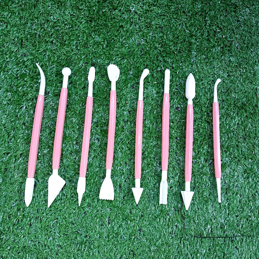 Set of dental tools with pink handles on a green grass background