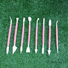 Set of dental tools with pink handles on a green grass background